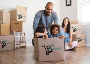 Image: a family surrounded by Get Moving boxes in their home.