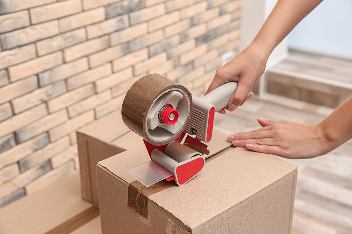 This image shows someone tapeing a box closed.