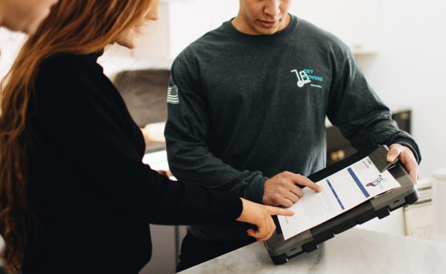 This picture shows a Get Moving professional showing a customer the details of the moving contract.
