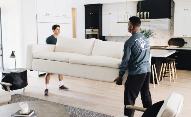 Image: Get Moving crew members moving a sofa.