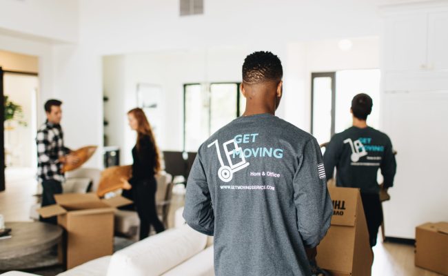 Image: Get Moving crew moving boxes in a house.